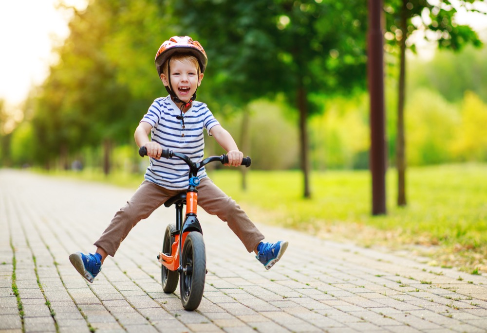 happy child boy rides a racetrack in Park in the summer